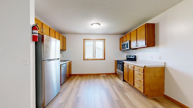 Bright kitchen featuring wooden cabinets and stainless steel appliances.